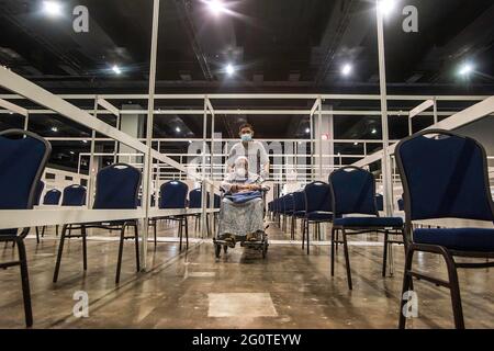 Kuala Lumpur, Malaisie. 29 mai 2021. Un homme déplace une femme âgée en fauteuil roulant vers la salle d'attente après avoir reçu le vaccin Covid-19 au Malaysia International Trade & Exhibition Centre. Le gouvernement malaisien va mettre en place plusieurs méga centres de vaccination pour renforcer la capacité de vaccination de Covid-19 et atténuer le problème de surpeuplement. (Photo par Vivian Lo/SOPA Images/Sipa USA) crédit: SIPA USA/Alay Live News Banque D'Images