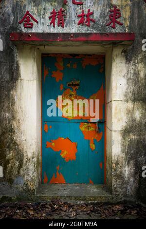 Peinture écaillée sur la porte métallique d'une nunnerie abandonnée, Tei Tong Tsai, île Lantau, Hong Kong. Banque D'Images