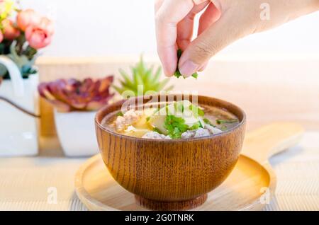 Soupe de viande de porc hachée et de soja dans un bol en bois. Banque D'Images