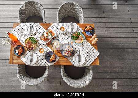 Vue de dessus d'une table dans un café sur une terrasse d'été, petit déjeuner ou déjeuner, en attente des clients. Placer pour le texte. Banque D'Images