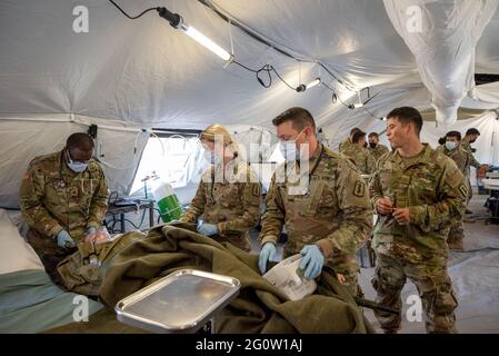 Baumholder, Allemagne. 03ème juin 2021. LES soldats AMÉRICAINS assistent à un soldat féminin blessé par balle au cours d'un exercice. Dans le cadre de l'exercice militaire « Deender Europe 21 » mené par les États-Unis, les forces de l'aire d'entraînement militaire des Baumholder ont notamment entraîné le transport et les soins des blessés. Credit: Harald Tittel/dpa/Alay Live News Banque D'Images