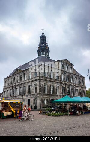 MAASTRICHT, 1ER JUIN : des personnes non identifiées marchent sur une place du marché en face d'une mairie de Maastricht, pays-Bas, le 1er juin 2013. L'hôtel de ville a été construit Banque D'Images