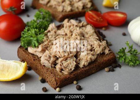 Sandwichs avec thon en conserve et ingrédients sur fond gris Banque D'Images