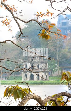 Branche de feuilles jaunes avec tour de tortue (tour Rua) sur la fondation du lac Ho Guom, le centre de Hanoi, beau paysage au printemps. Banque D'Images