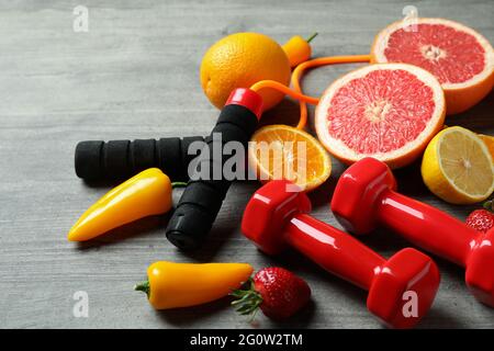 Nourriture saine, corde à sauter et haltères sur fond gris texturé Banque D'Images