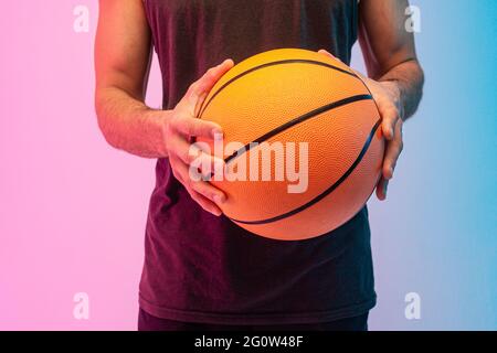 Gros plan de l'homme tenir le ballon de basket-ball dans les mains Banque D'Images