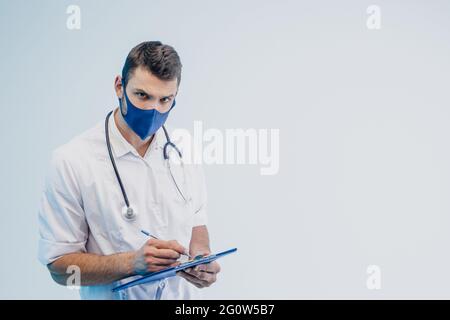Un médecin européen écrit quelque chose dans le presse-papiers Banque D'Images