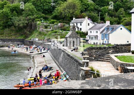 Les gens apprécient leur temps sur la plage dans la pittoresque MCG-yr-Eglwys, Pembrokeshire, au sud du pays de Galles. Il a été rapporté que le petit village de bord de mer a plus de maisons de vacances que les résidents permanents, avec les locaux étant hors prix du marché de l'immobilier. Seulement deux des cinquante propriétés du village abritent maintenant des locaux. Banque D'Images