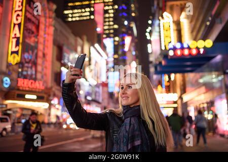 Femme souriante prenant le selfie dans le célèbre centre-ville Banque D'Images