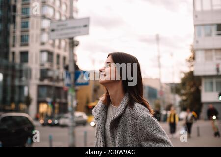 Portrait d'une heureuse femme non binaire debout dans la rue en ville Banque D'Images