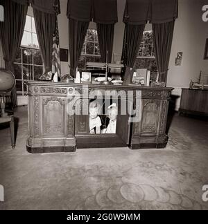 ST-C221-2-63 22 JUIN 1963 Caroline, fille du Président John F. Kennedy, et une amie sous le bureau du Président dans le Bureau ovale de la Maison Blanche. Veuillez créditer « Cecil Stoughton (Harold Sellers) ». Photos de la Maison Blanche. John F. Kennedy Presidential Library and Museum, Boston Banque D'Images