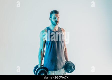 Un sportif sérieux tenant un haltères en studio Banque D'Images