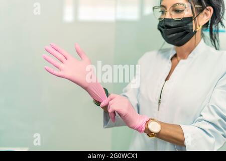 femme médecin mettant ses gants en latex avant la chirurgie Banque D'Images