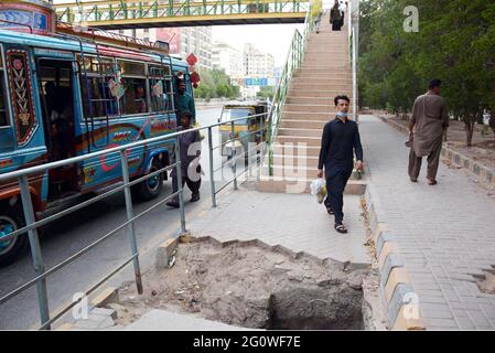 Pakistan. 3 2021 juin : les navetteurs passent à proximité d'un trou principal ouvert d'assainissement à proximité du pont piétonnier qui peut causer tout accident, en particulier la nuit, montrant la négligence des départements concernés, situé sur la route Shahrah-e-Faisal à Karachi le jeudi 03 juin 2021. Credit: Asianet-Pakistan/Alamy Live News Banque D'Images