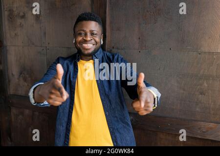 Hé vous. Vous êtes le prochain. Je vous choisis. Un homme afro-américain débordant de joie pointant les doigts vers un appareil photo posé en studio ou à la maison. Bannière publicitaire avec Banque D'Images