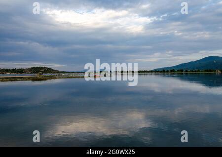 Plage de Livari au coucher du soleil dans la baie naturelle exotique de Vourvourou, péninsule de Sithonia, Halkidiki, Grèce et le Mont Athos en arrière-plan. Banque D'Images