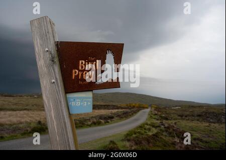 Le sentier de l'oiseau de proie signe à la réserve naturelle du Loch Druidibeag RSPB, South Uist. Panneau en métal avec motif oiseau découpé. Arrière-plan rural et routier. Banque D'Images