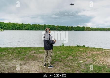 Homme jouant avec drone pour examen. Silhouette contre le paysage de printemps frais.Homme utilisant le drone par télécommande et d'avoir plaisir. Pilote volant Banque D'Images