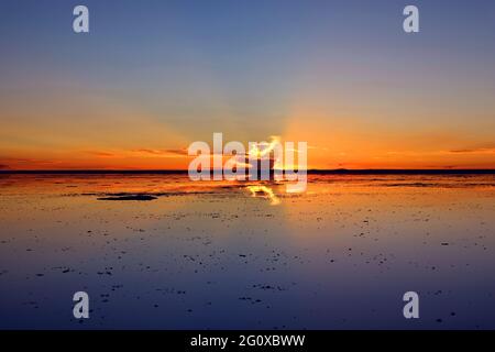 Reflet du ciel du coucher du soleil sur les crues salées, l'effet miroir emblématique à Salar de Uyuni en Bolivie, en Amérique du Sud Banque D'Images