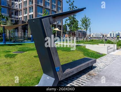 Un chargeur de téléphone portable solaire intégré dans un siège public à Hanover Quay, Dublin, Irlande. Banque D'Images