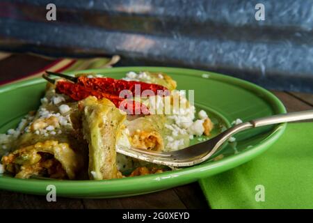 Enchiladas mexicaines avec une sauce crémeuse au poivre de poblano et du fromage en plein air queso Banque D'Images