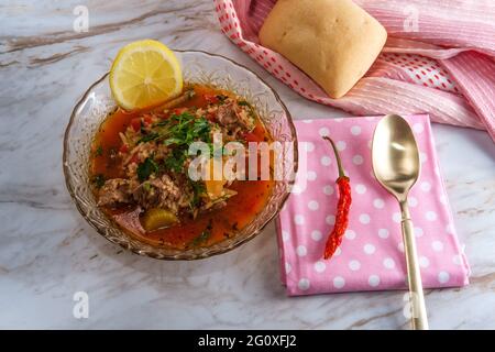 Soupe traditionnelle de bœuf de Kharcho de la Géorgie du pays servie avec un piment sec et une tranche de citron Banque D'Images