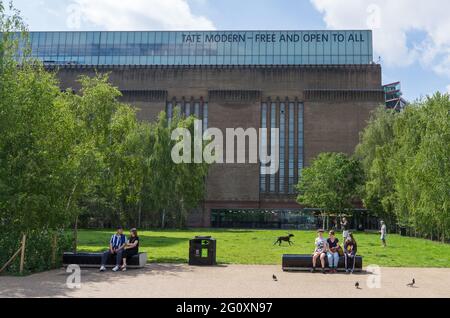 Tate Modern Art Gallery le long de la rive sud de la Tamise. Les gens ont vu s'asseoir sur des bancs lors d'un chaud jour d'été à Londres Banque D'Images