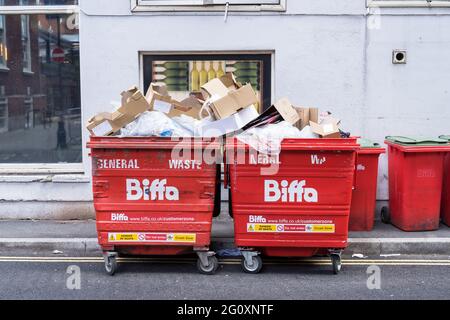 Des poubelles de Biffa rouges débordant de déchets dans la rue. Londres Banque D'Images