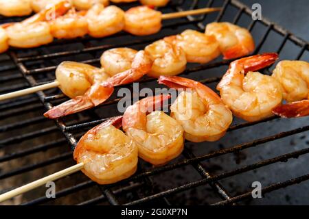 Griller des kebabs de crevettes bourban juteux au-dessus du charbon de bois sur le gril Banque D'Images