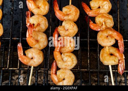 Griller des kebabs de crevettes bourban juteux au-dessus du charbon de bois sur le gril Banque D'Images