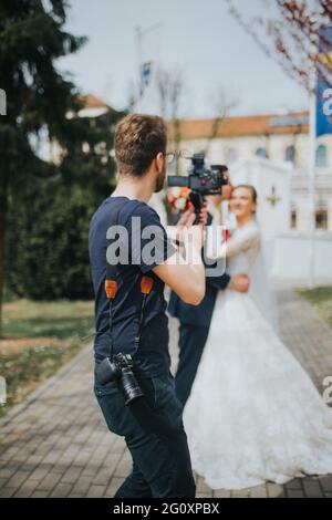 La photo avec mise au point peu profonde d'un photographe de mariage prend des photos de la mariée et du marié Banque D'Images