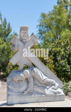 Santa Inez, CA, Etats-Unis - 3 avril 2009: San Lorenzo Seminary. Gare de la Croix numéro 9 statue en marbre blanc. Jésus tombe pour la troisième fois. Feuillage vert Banque D'Images