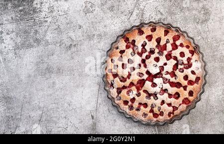 Tarte à la framboise maison dans un plat à pâtisserie en verre sur fond gris foncé. Vue de dessus, plan d'appartement Banque D'Images