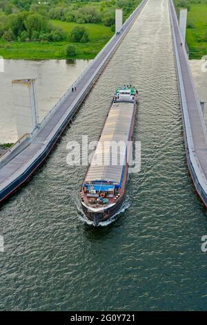 Magdebourg, Allemagne. 21 mai 2021. Une barge traverse la jonction de la voie navigable de Magdeburg. Le canal Mittelland traverse l'Elbe à ce point dans un pont à travers. D'une longueur de 918 mètres, c'est le plus grand pont de canal d'Europe. (Photo prise avec un drone) Credit: Stephan Schulz/dpa-Zentralbild/ZB/dpa/Alay Live News Banque D'Images