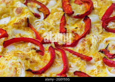 Gros plan de pizza nappée de poivre rouge, d'oignon et de sauce au curry jaune. Photo macro de produits délicieux. Banque D'Images