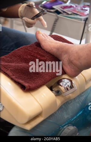 Une femme hispanique de 84 ans se fait offrir un ensemble pédicure/manucure dans son salon de beauté local. Banque D'Images