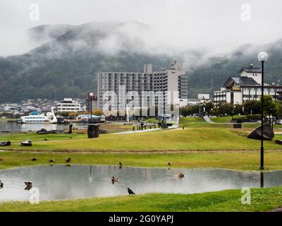 Suwa, Japon - 21 octobre 2017 : jour de pluie au parc Suwa Lakeside avec de lourds nuages couvrant les montagnes autour du lac Suwako Banque D'Images