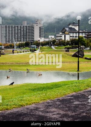 Suwa, Japon - 21 octobre 2017 : jour de pluie au parc Suwa Lakeside avec de lourds nuages couvrant les montagnes autour du lac Suwako Banque D'Images