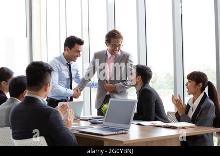 Poignée de main entre le chef de l'étranger et de l'Asian manager qui peut mener à bien le projet qui fait de l'entreprise tirer profit de l'assemblée Banque D'Images