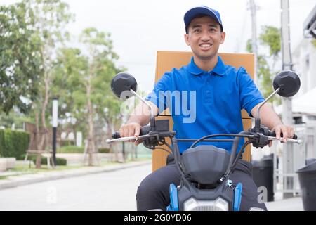 Livreur sur la moto à coffre boîte à colis de conduite rapide en rush. La prestation de service de messagerie en ligne de commande. Livraison express dans des délais spécifiés par l'al. Banque D'Images