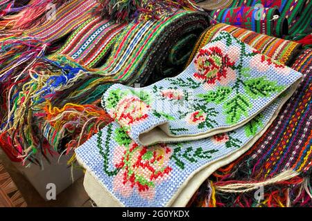 Gros plan sur les vêtements ukrainiens - chemises brodées traditionnelles et ceintures ornées de perles. Produits d'occasion sur le marché aux puces, thrift shopping concept. Sélectif Banque D'Images