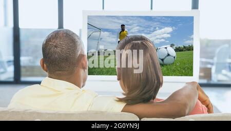 Composition d'un couple regardant un match de football à la télévision à la maison Banque D'Images