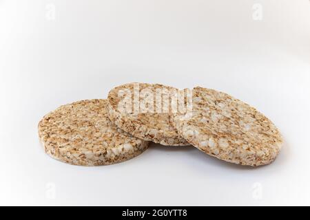 croquant gâteaux de riz sur fond blanc, trois croustillants de grains entiers isolés, gros plan, vue latérale Banque D'Images