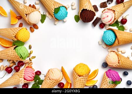 Assortiment de glaces en cônes sur fond blanc. Ensemble coloré de crème glacée aux saveurs différentes. Crème glacée isolée avec des noix, des fruits et des baies. Banque D'Images