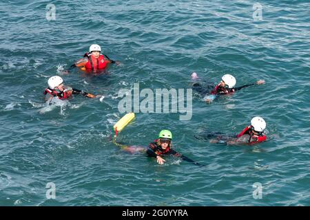 Les vacanciers et leur guide nageant dans la mer lors d'une aventure de codirection sur Towan Head à Newquay en Cornouailles. Banque D'Images