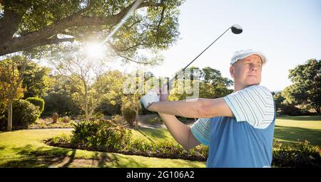 Composition de l'homme caucasien jouant au golf frappant avec le club de golf Banque D'Images