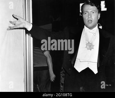 ORSON WELLES sur le terrain Candid pendant le tournage de SUIVRE LES GARÇONS 1944 réalisateur A. EDWARD SUTHERLAND producteur Charles K. Feldman robes Vera West Universal Pictures Banque D'Images