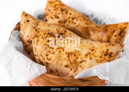 Empanadas chiliennes traditionnelles dans un panier isolé sur fond blanc Banque D'Images