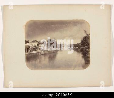 Le Mas Kali. Le Mas Kali à Genteng à Soerabaya avec un haut mur de quai avec des maisons. Un certain nombre d'échelles sont suspendues dans l'eau du quai. À droite de la rivière, le quai est surcultivé et il y a des arbres. Partie de l'album photo des fabricants Surabayasche Vereeniging van Sugar offert à Frederik Beyerinck, résident de Surabaya. Banque D'Images