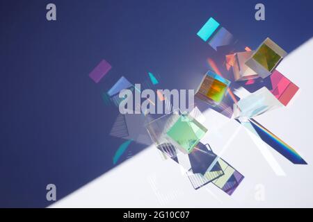 Arrière-plan abstrait avec des figures géométriques en verre prismes avec diffraction de la lumière des couleurs du spectre et réflexion complexe. Banque D'Images